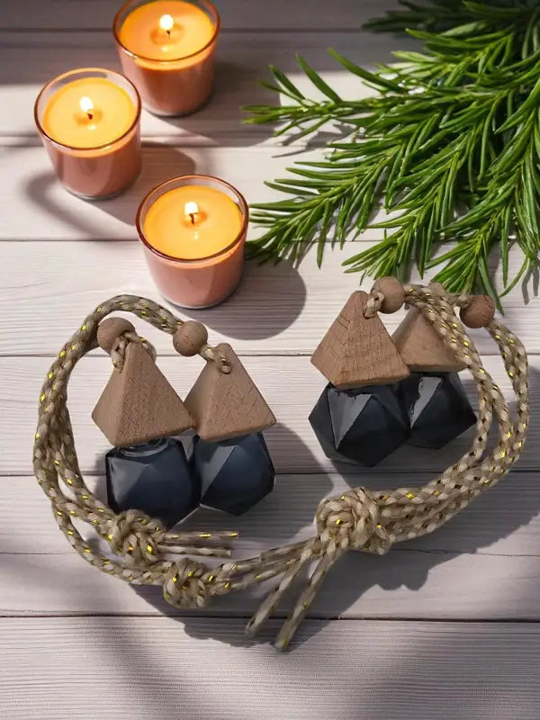 Four glass rosemary car diffuser with wooden cap, styled with rosemary sprigs and candles on a light wood surface Homestead Lavender Farm.