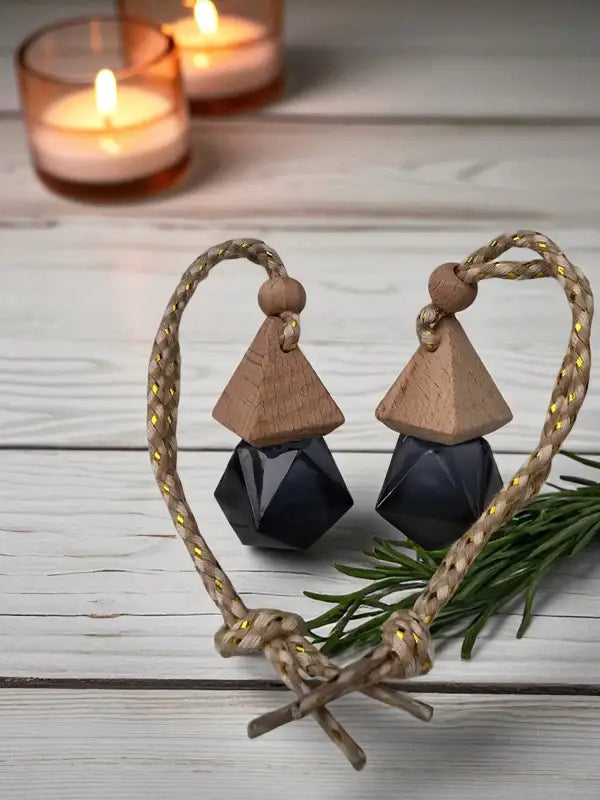 Two glass rosemary car diffuser with wooden cap, styled with rosemary sprigs and candles on a light wood surface Homestead Lavender Farm.