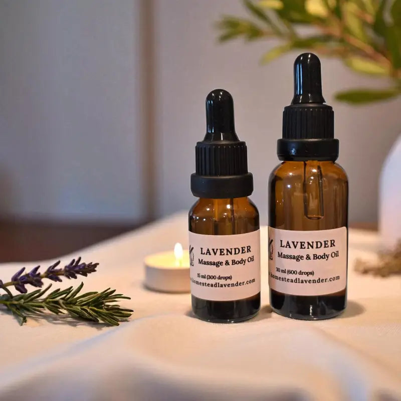 15 & 30ml amber glass vials of lavender massage oil with candles and sprigs of lavender