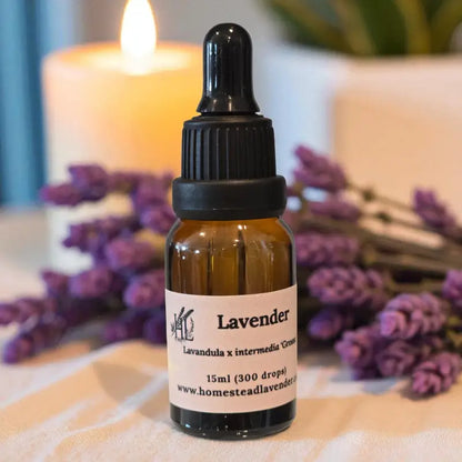 Amber bottle of 100% pure, steam-distilled lavender oil (15ml), with dropper and fresh lavender, made at Homestead Lavender Farm.
