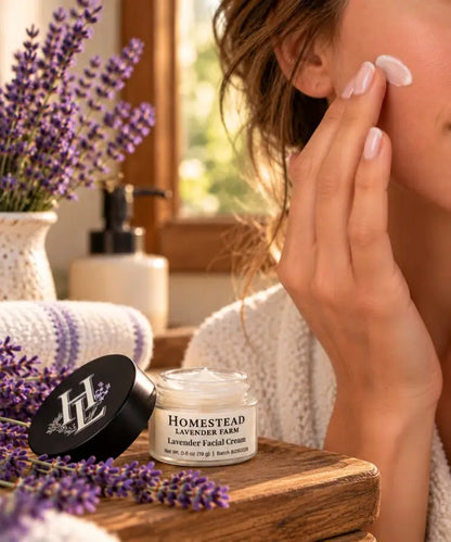 Woman smoothing Lavender Facial Cream onto her cheek, open jar beside her