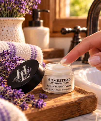 Fingertip dipping into the open jar of Lavender Facial Cream showing its soft texture